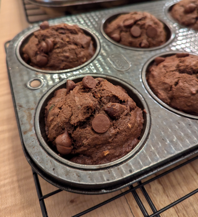 Muffin pan on cooling wrack with chocolate zucchini muffins