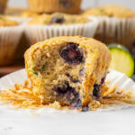 Zuchhini blueberry muffin sitting on a plate with a bite taken out of it.