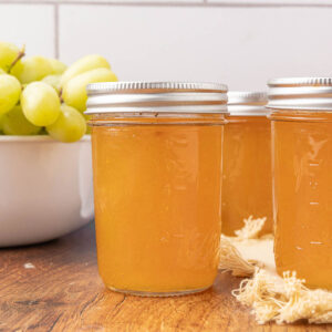 Jars of grape jelly sitting on a countertop.