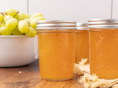 Jars of grape jelly sitting on a countertop.
