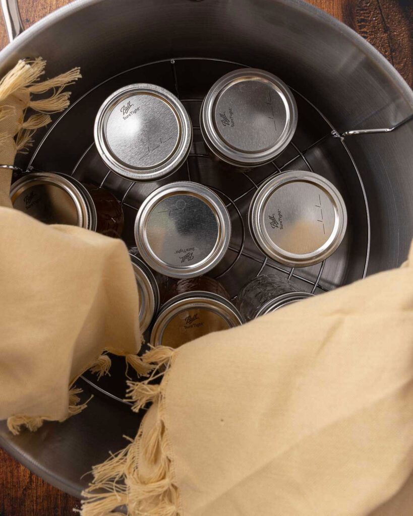 Jars of grape jelly processing in a water bath canner.