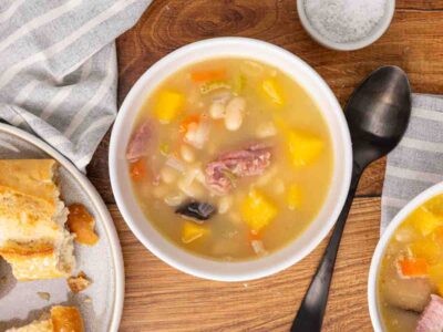 Ham and bean soup served in a white bowl.