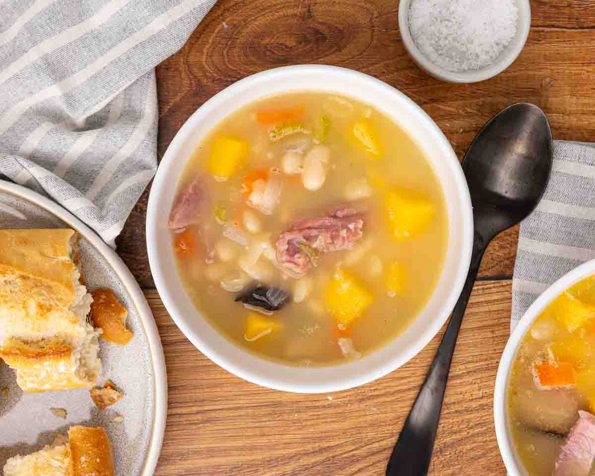 Ham and bean soup served in a white bowl.