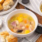 Ham and bean soup served in a white bowl.