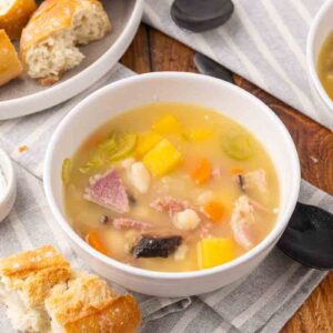 Ham and bean soup served in a white bowl.