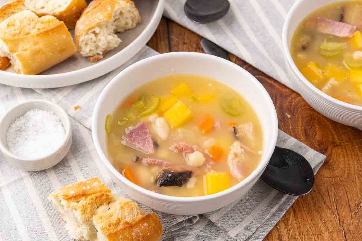 Ham and bean soup served in a white bowl.