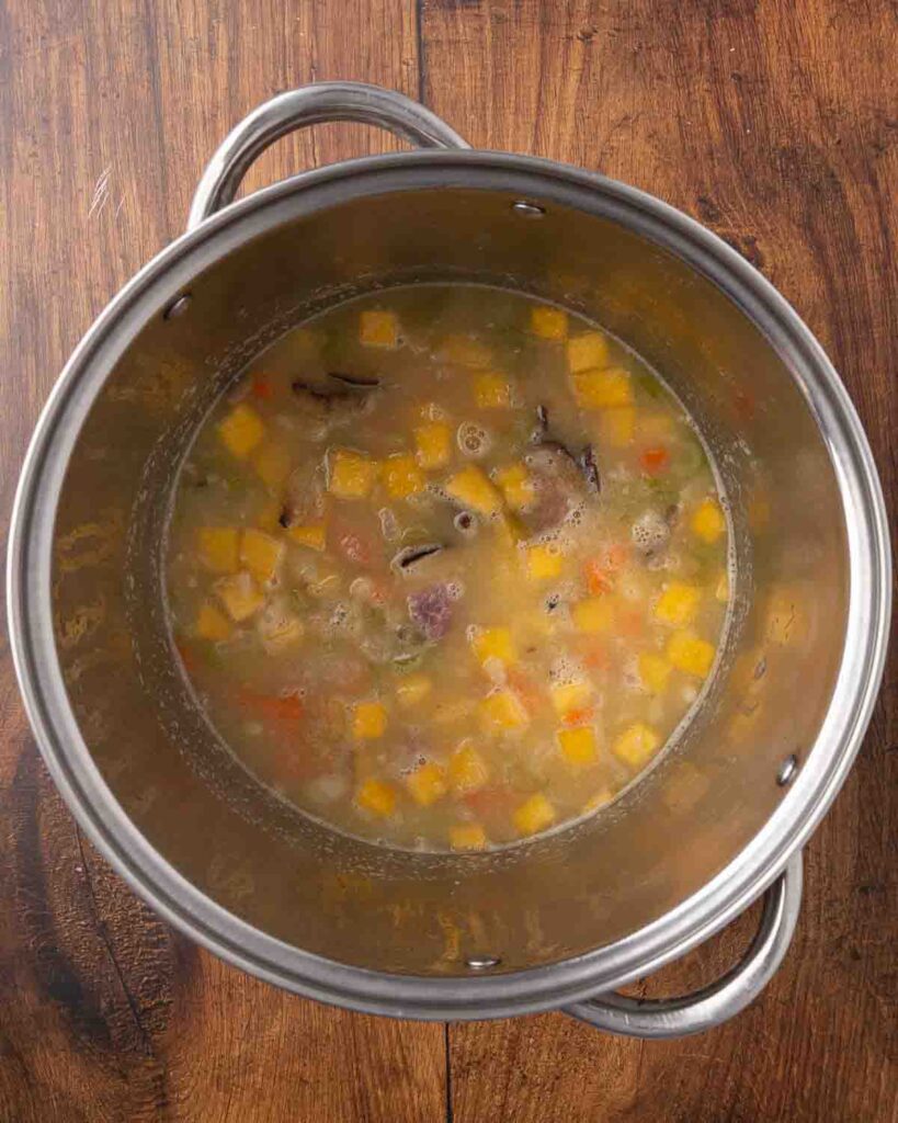 Bird's eye view of ham and bean soup in a stock pot.