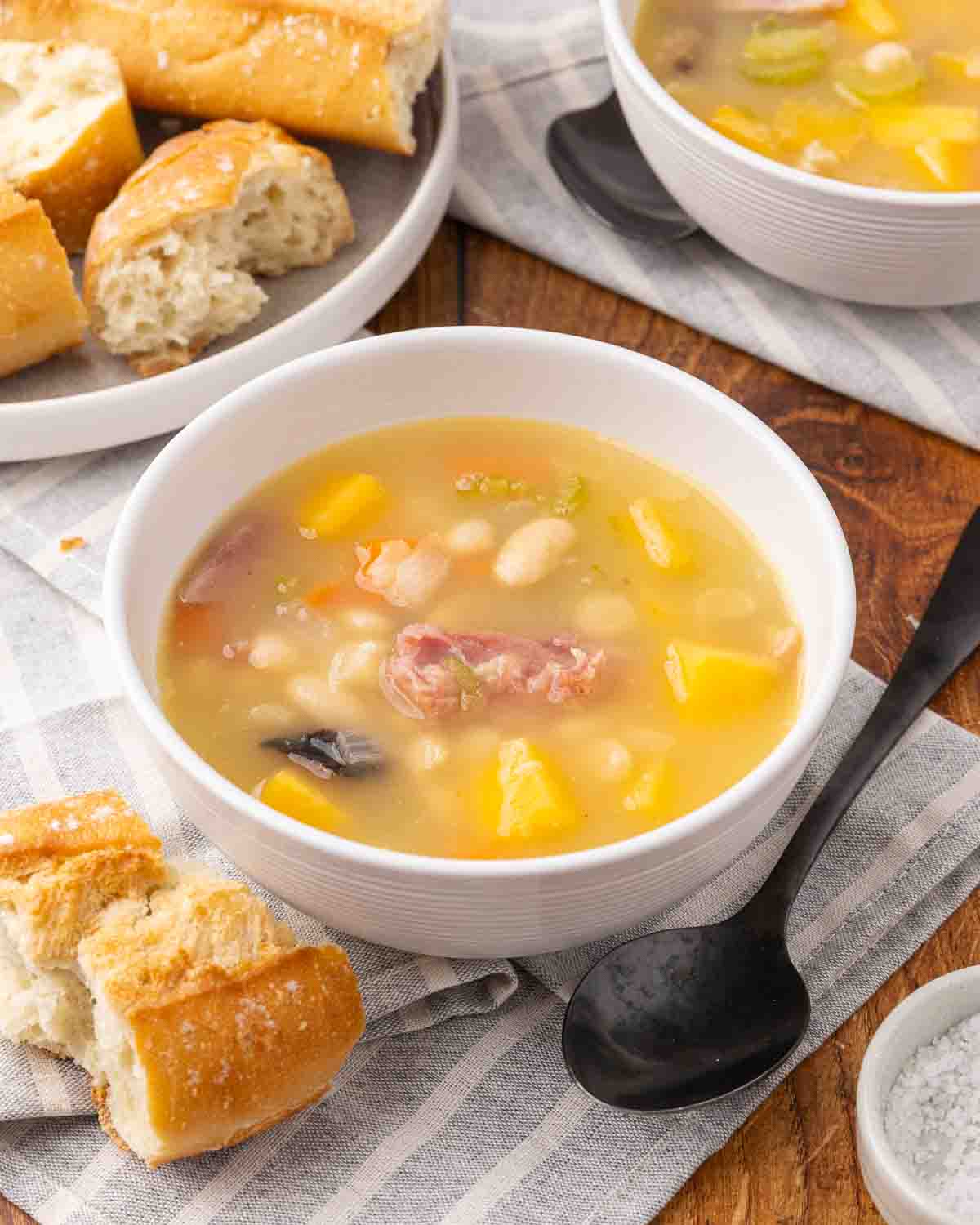 Ham and bean soup served in a white bowl.