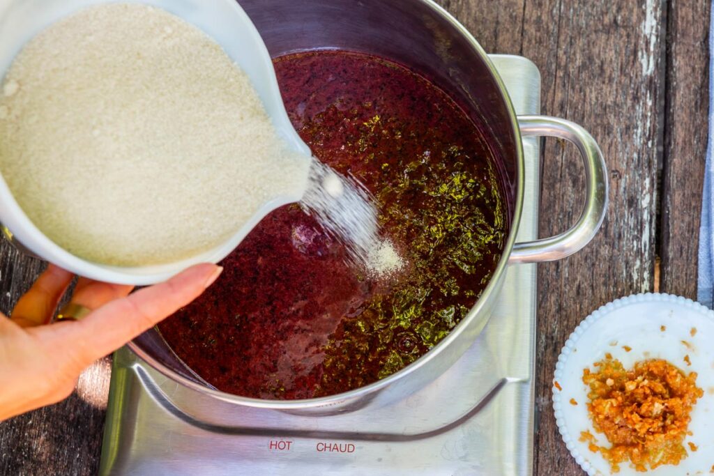 Sugar being added to blueberry jam.