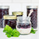 Jars of blueberry jam with a jar of yogurt topped with blueberry jam.