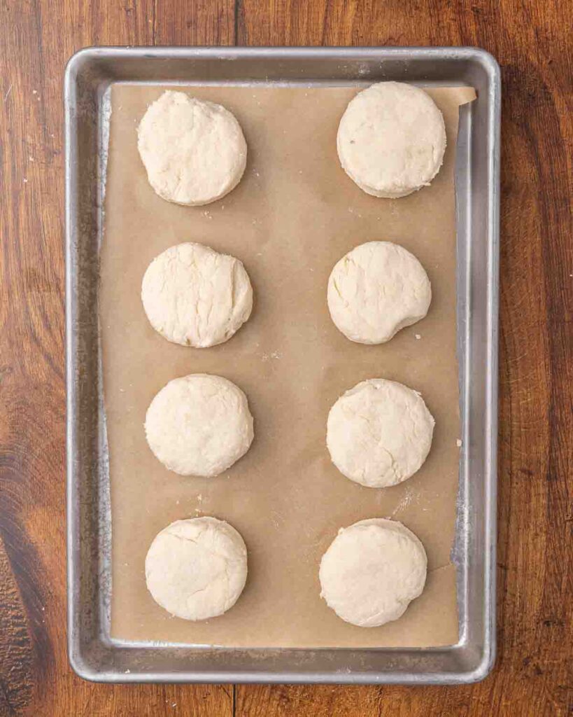Cut biscuit dough arranged on a baking sheet ready for the oven.
