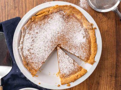 A baked vinegar pie with a slice missing.