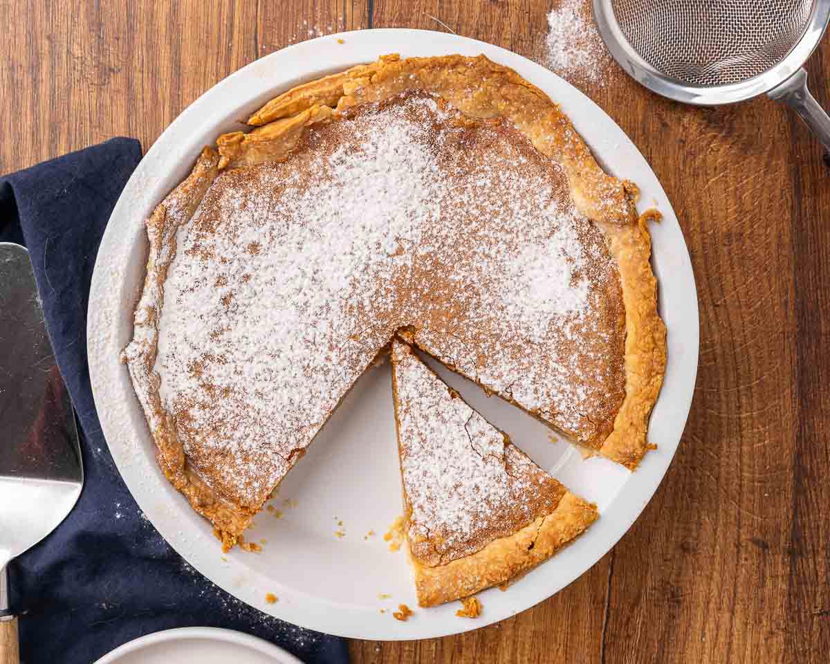 A baked vinegar pie with a slice missing.