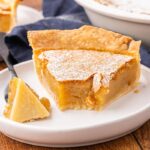 A slice of vinegar pie with a bite removed to show texture.