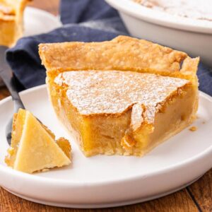 A slice of vinegar pie with a bite removed to show texture.