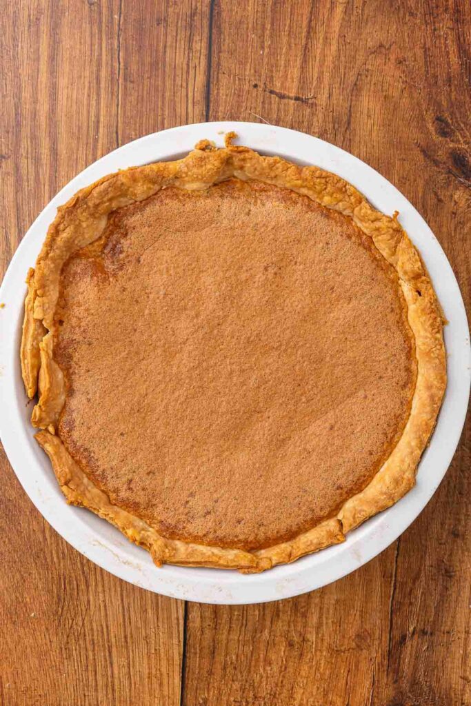 A baked vinegar pie, cooling on a countertop.