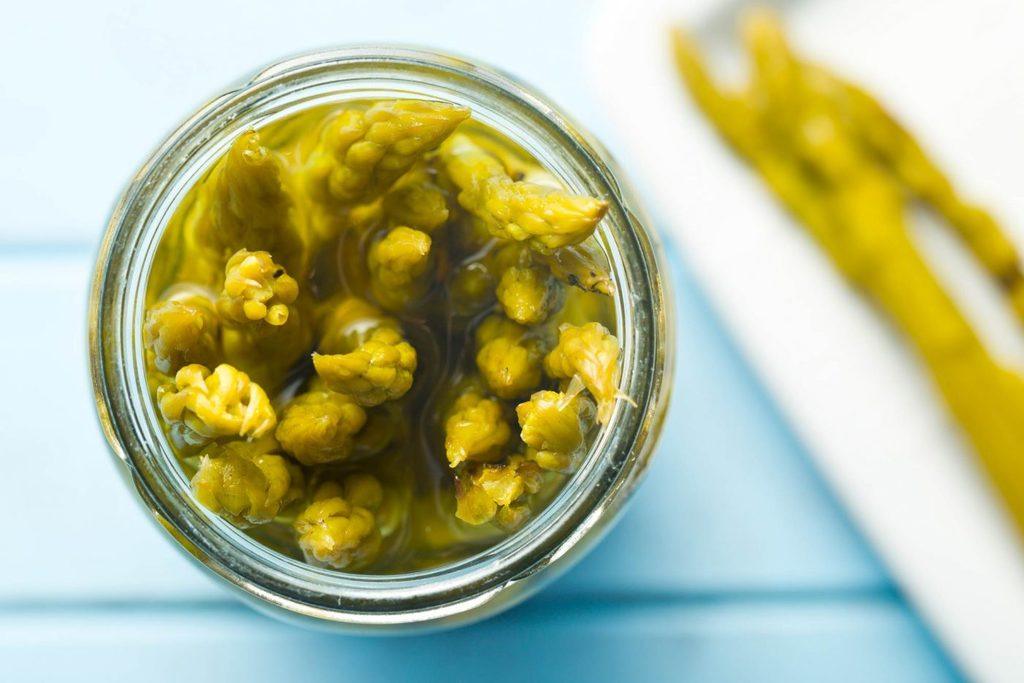 Up close vertical shot of pickled asparagus in a jar.