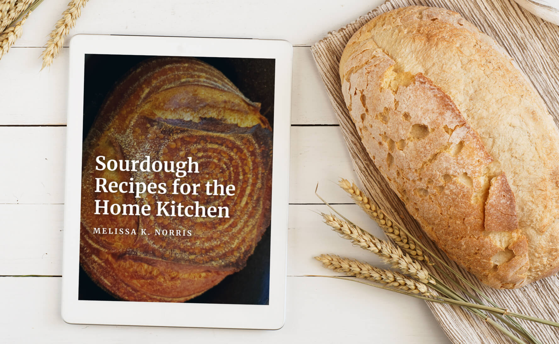 sourdough ebook on table with loaf of sourdough bread