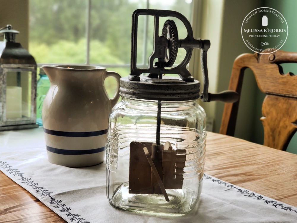 antique butter churn on table