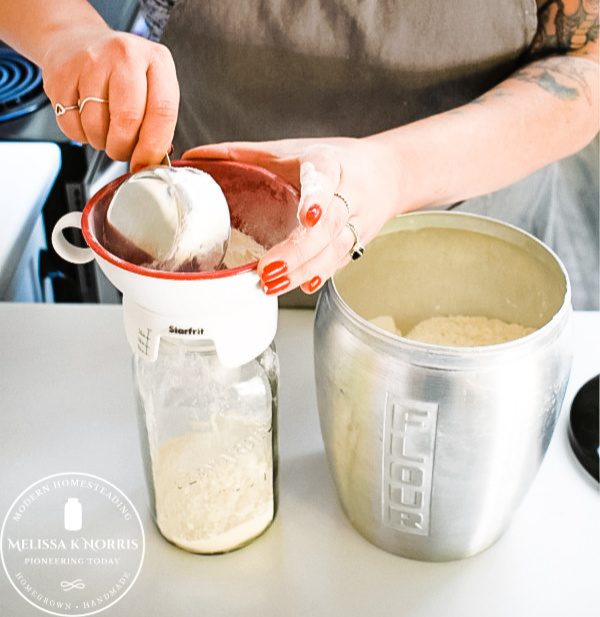 pouring flour into Mason jar for homemade pancake mix
