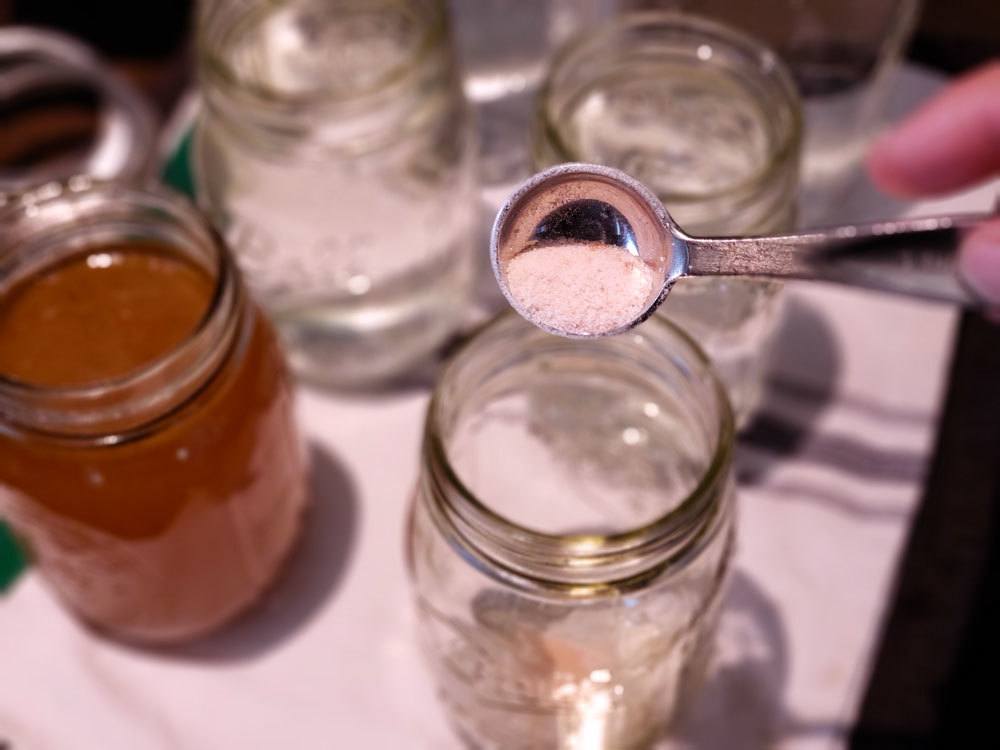 Salt being added to a mason jar.