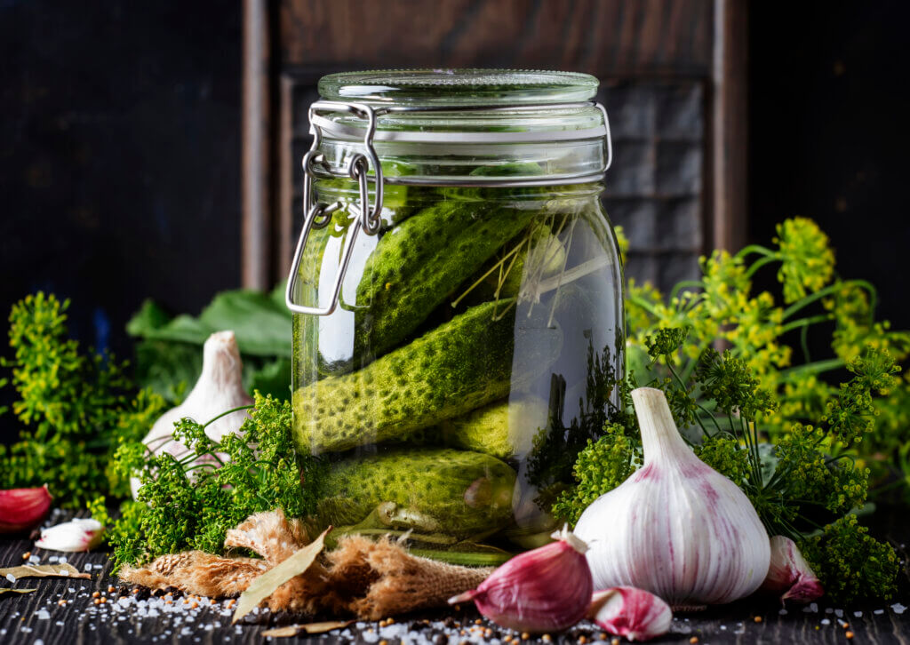 A jar of pickled cucumbers with dill and garlic.