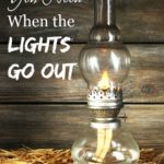 Picture of an antique kerosene lamp sitting on a bed of hay with barn wood in the background. Text overlay says, "4 Things You Need When the Lights Go Out".