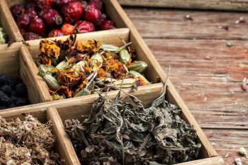 A wooden box with dried herbs. Text overlay says, "7 Herbs for Natural Remedies Your Great Grandparents Used".