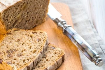 Image of a loaf of bread being sliced on a cutting board. Text overlay says, "Homesteading for Beginners: 9 Transition Tips from City Life to Homesteader".