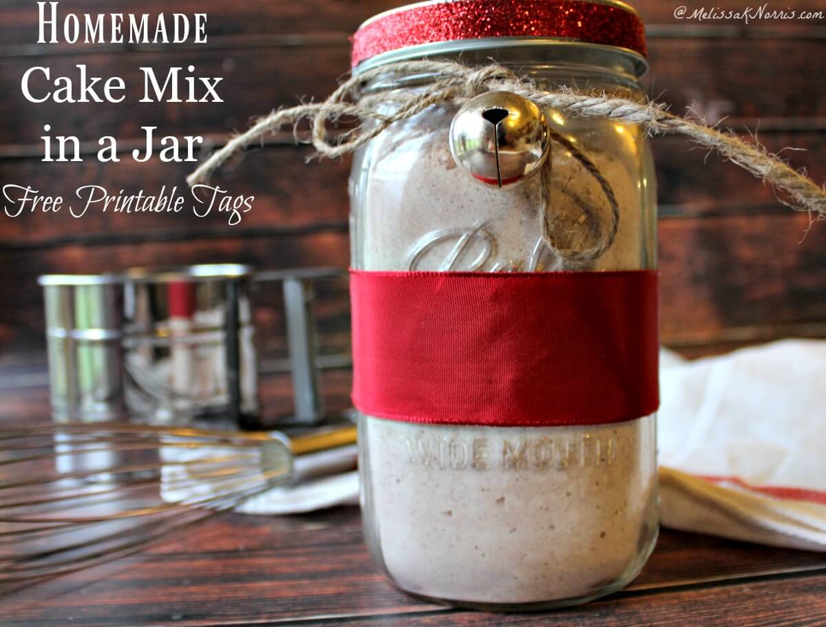 A jar of homemade cake mix tied with red ribbon and a bell.