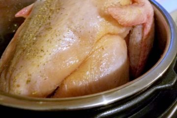 A whole raw chicken in the Instant Pot. Text overlay says, "How to Cook a Frozen Whole Chicken in the Instant Pot".