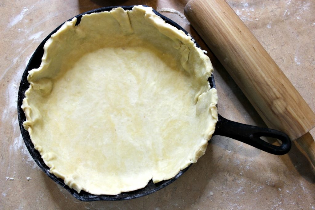 homemade pie crust in cast iron skillet on counter