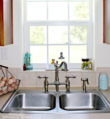 Image of a sparkling clean stainless steel sink with a basket of fresh eggs to the side. Text overlay says, "12 Tips to Declutter & Organize Your Homestead So it Actually Stays that Way - With 100 Year Old Strategies".