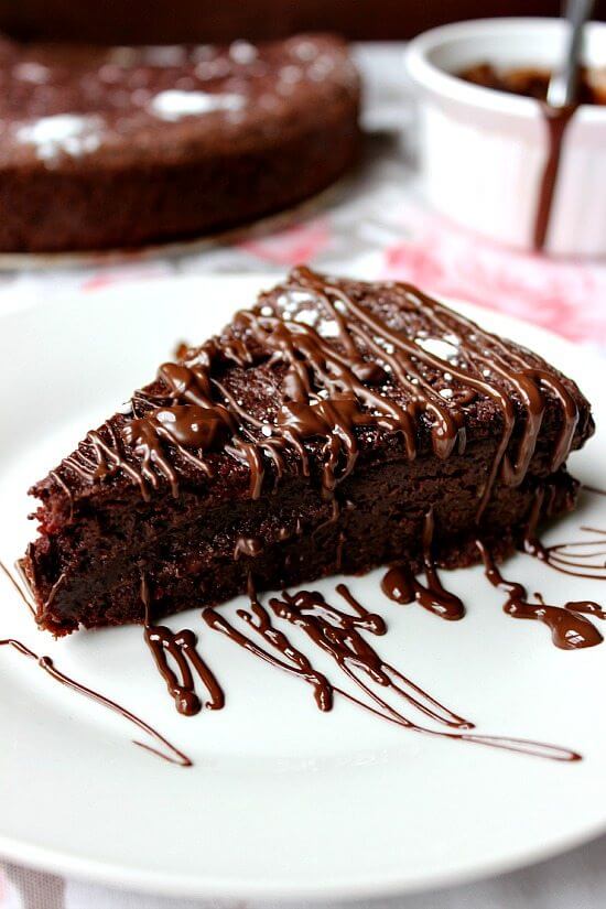 Chocolate beet cake on a plate drizzled with more chocolate.