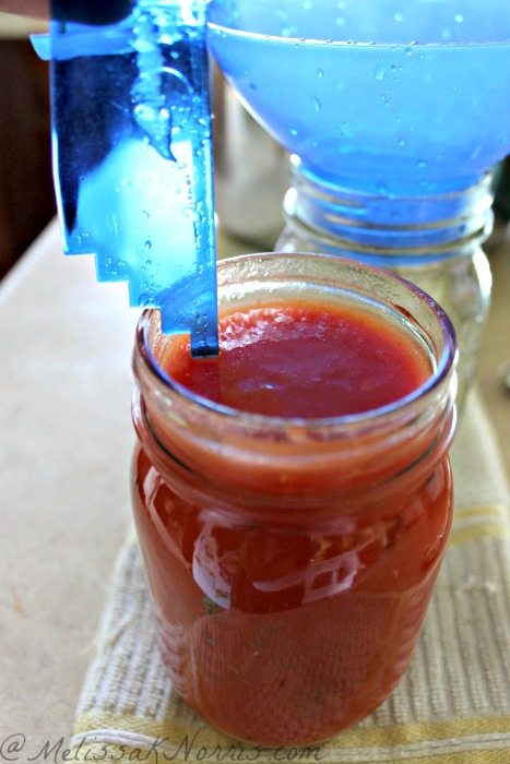 Jar of tomato sauce with a head space measuring tool in the top.