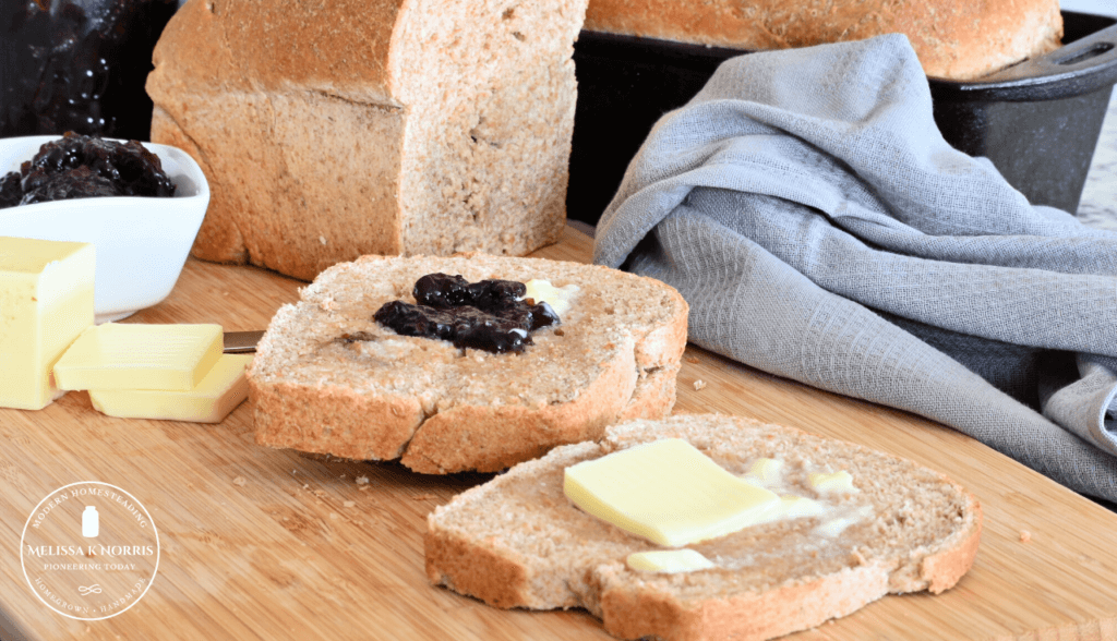 Pinterest pin with two images. Top image dough in a kitchen aid mixing bowl with dough hook. Bottom image is fluffy slices of bread. Text overlay says, "Honey Whole Wheat Buttermilk Sandwich Bread"