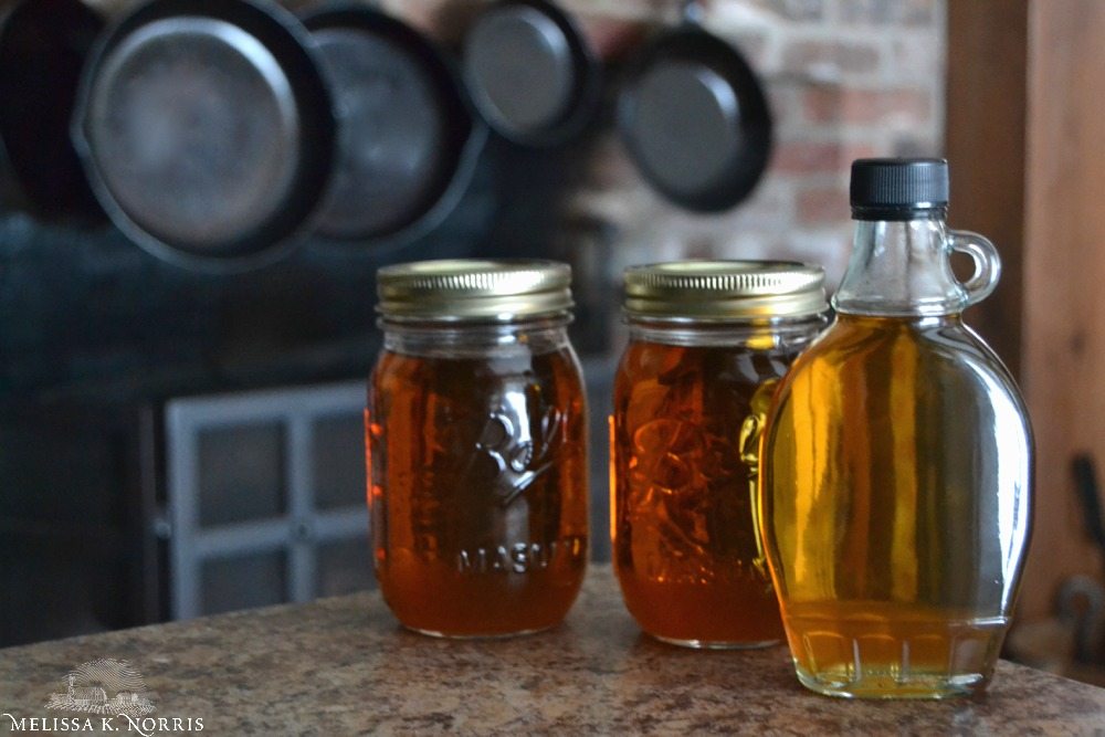 Jars of maple syrup on a counter.