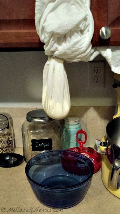 A hanging tea towel folded up with yogurt inside to strain.