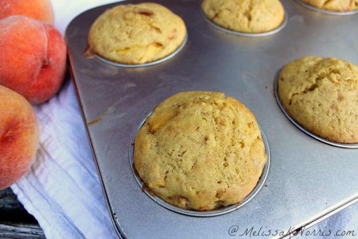 Peach muffins in a muffin tin.