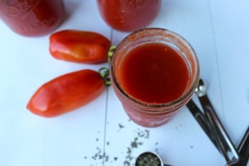 Jars of canned tomato sauce on a countertop.