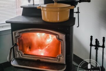 Picture of a wood stove with a pot on top.