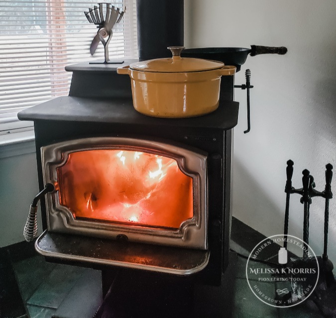 Picture of a wood stove with a pot on top.