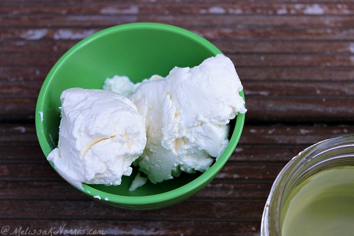 yogurt cheese in a green bowl on a wooden table.