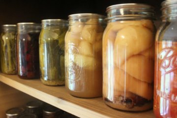 Home canned jars of food on a shelf.