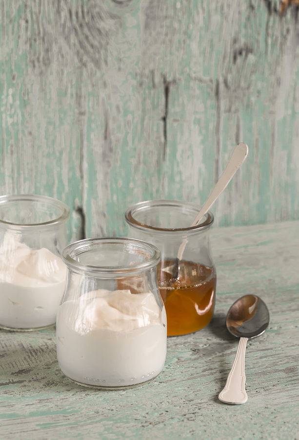 Two jars of yogurt and a jar of honey.