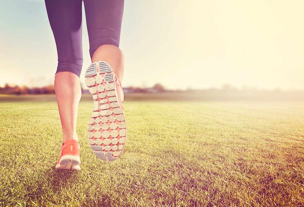 Image of a woman's legs in running shoes running away from the camera.