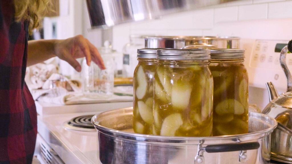 Mason jars filled with apple pie filling sitting in a steam canner.