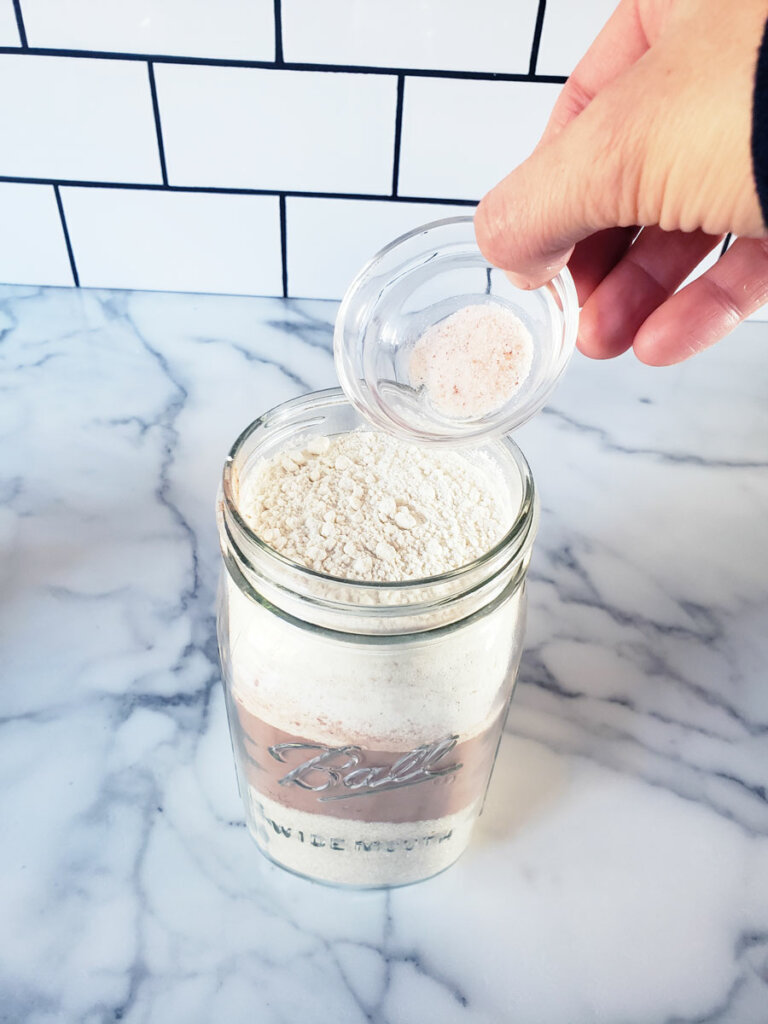 Salt being poured into a mason jar.