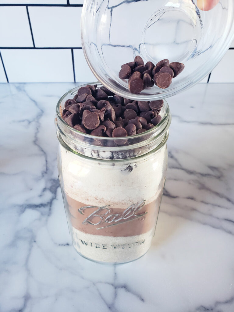 Chocolate chips being poured into a mason jar.