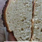 Pinterest pin for artisan bread with an image of a loaf of bread sliced open to reveal the soft crumb.